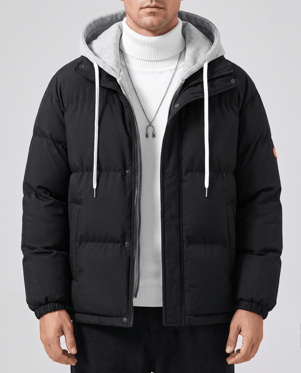 A man wearing a black quilted hooded puffer jacket with drawstring hood and zip pockets