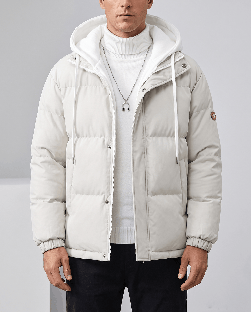 A man wearing a white quilted hooded puffer jacket with drawstring hood and zip pockets