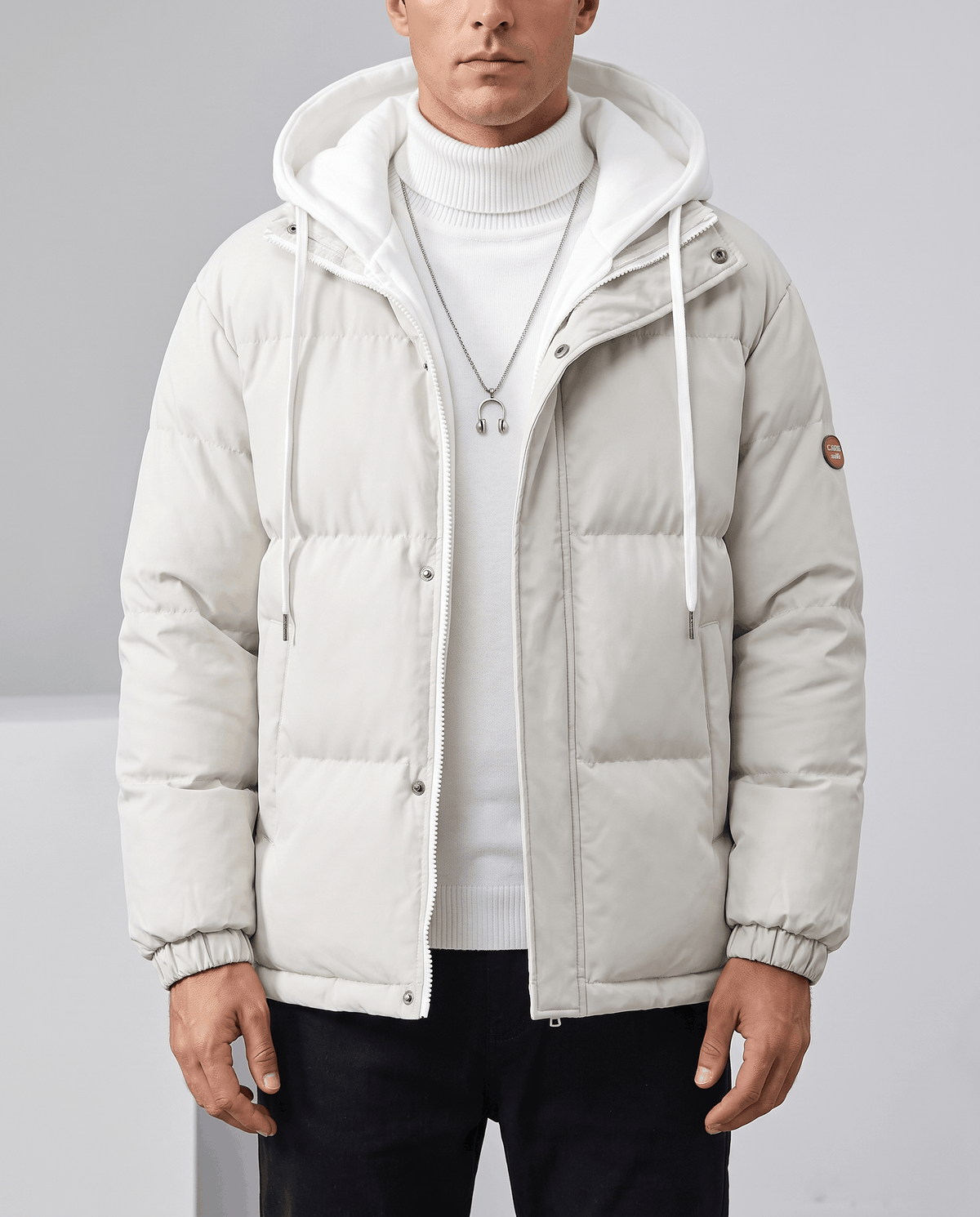 A man wearing a white quilted hooded puffer jacket with drawstring hood and zip pockets