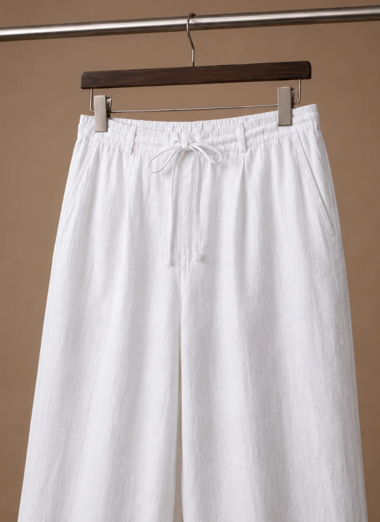 Close-up of men's white linen drawstring pants highlighting the elastic waistband and adjustable drawstring.