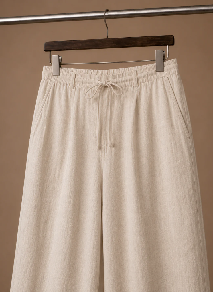 Close-up of men's cream linen drawstring pants showcasing the elastic waistband and adjustable drawstring.