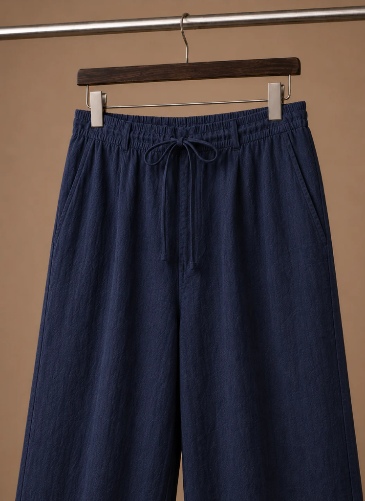 Close-up of men's navy linen drawstring pants highlighting the elastic waistband and adjustable drawstring.