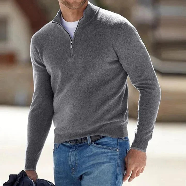 Gray half-zip knit sweater with a stand collar and long sleeves, styled with blue jeans for a smart casual look.