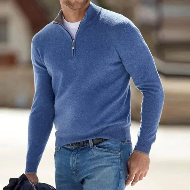 Blue half-zip knit sweater featuring a stand collar and long sleeves, styled with blue jeans outdoors.