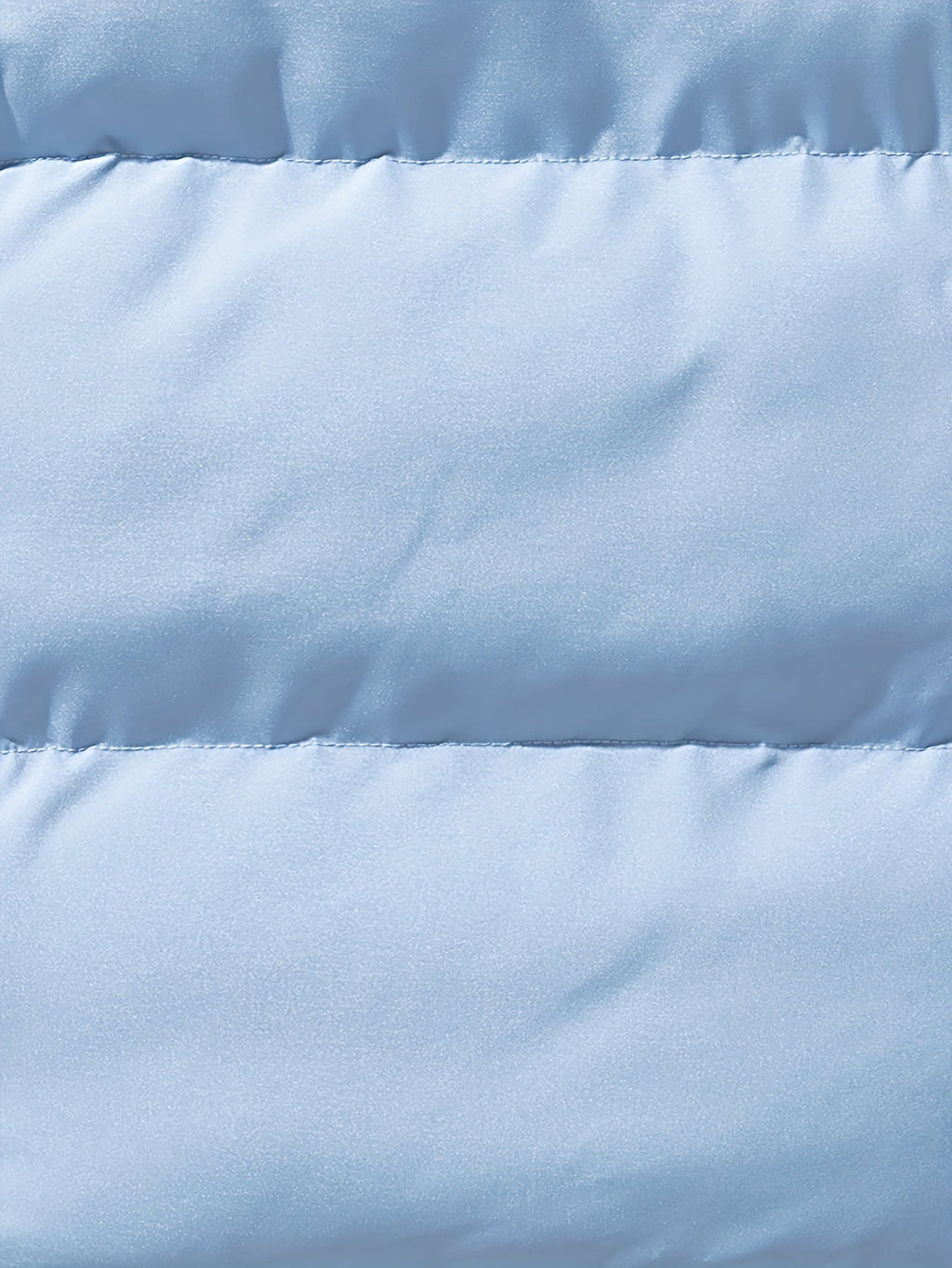 Close-up of a light blue quilted jacket showing the padded shell texture