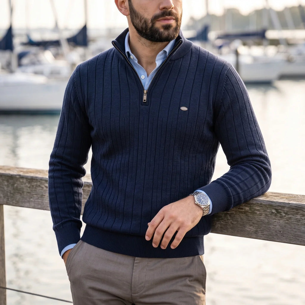Navy blue ribbed knit quarter-zip sweater with a mock neck, layered over a light blue collared shirt by a marina.