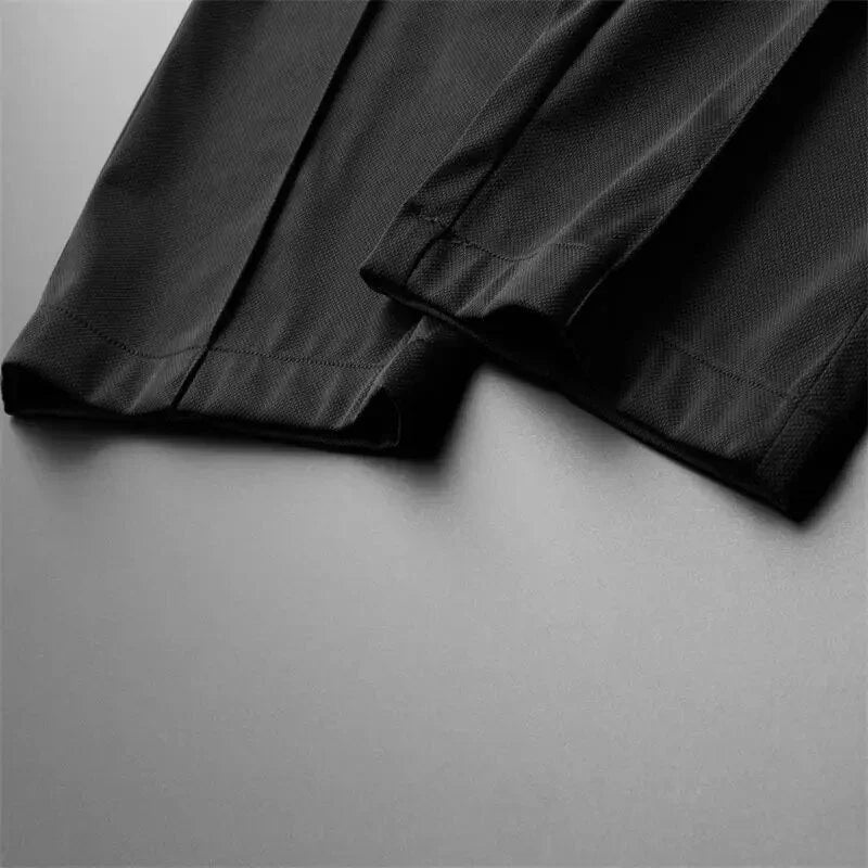 Close-up of the black pant leg cuffs showing clean stitching and tailored finishing.