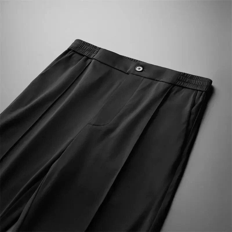 Flat lay of men's black straight-leg pants showcasing the front design and waistband.