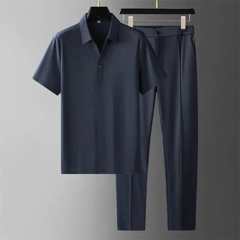Men's navy short-sleeve polo shirt with black straight-leg pants displayed as a coordinated casual outfit.