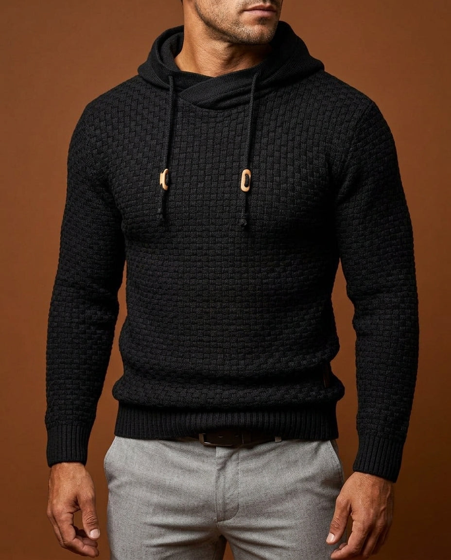 Man wearing black textured knit hooded sweater with wooden toggle drawstrings, close-up front view