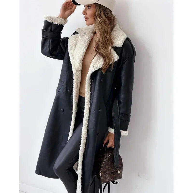 Black shearling trench coat with a cream teddy lining, double-breasted buttons, and a belted waist in a longline fit.