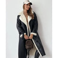 Black shearling trench coat with cream teddy lining, wide collar, and belted waist in a longline silhouette.