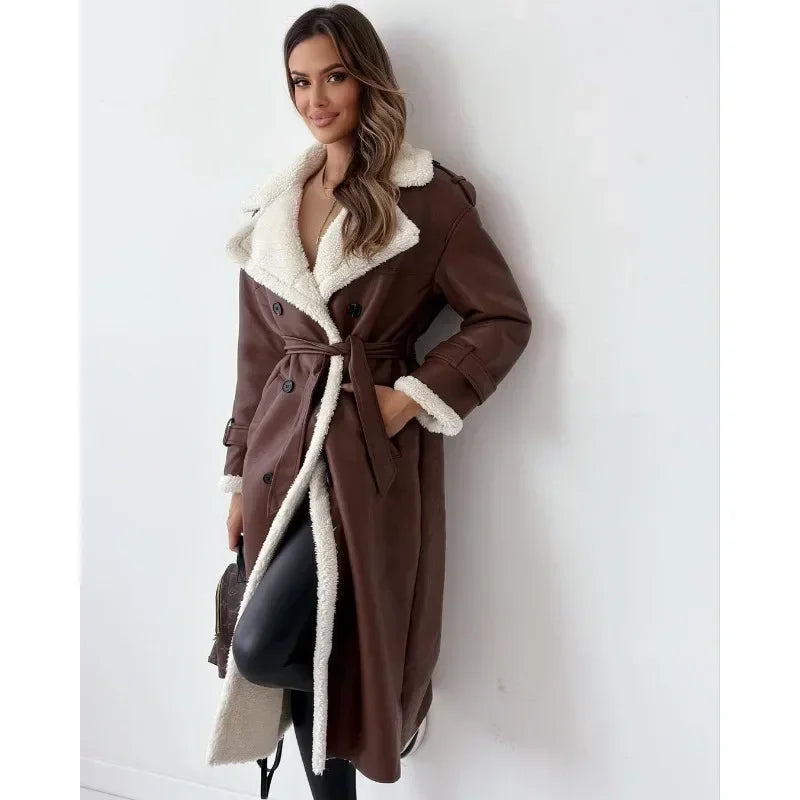 Brown shearling trench coat with cream teddy lining, double-breasted buttons, and a belted waist in a longline fit.