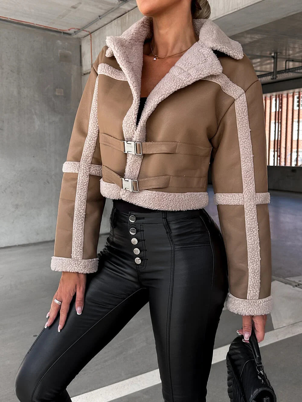 Cropped beige leather aviator jacket with plush sherpa trim, wide collar, and adjustable waist buckle straps. 