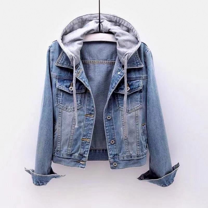 Women's light wash denim jacket with a detachable gray hood, button-front closure, chest flap pockets, and rolled cuffs.