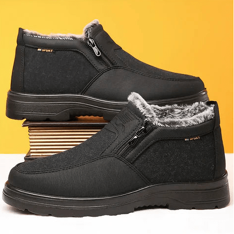 Black side-zip winter boots for men with fur lining, cushioned insert, and rugged tread, angled view