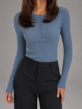 Woman wearing a blue ribbed knit sweater with a button-front crew neckline, long sleeves, and a slim fitted silhouette.