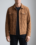 A man wearing a brown soft suede jacket with a relaxed fit, chest pockets, and side pockets