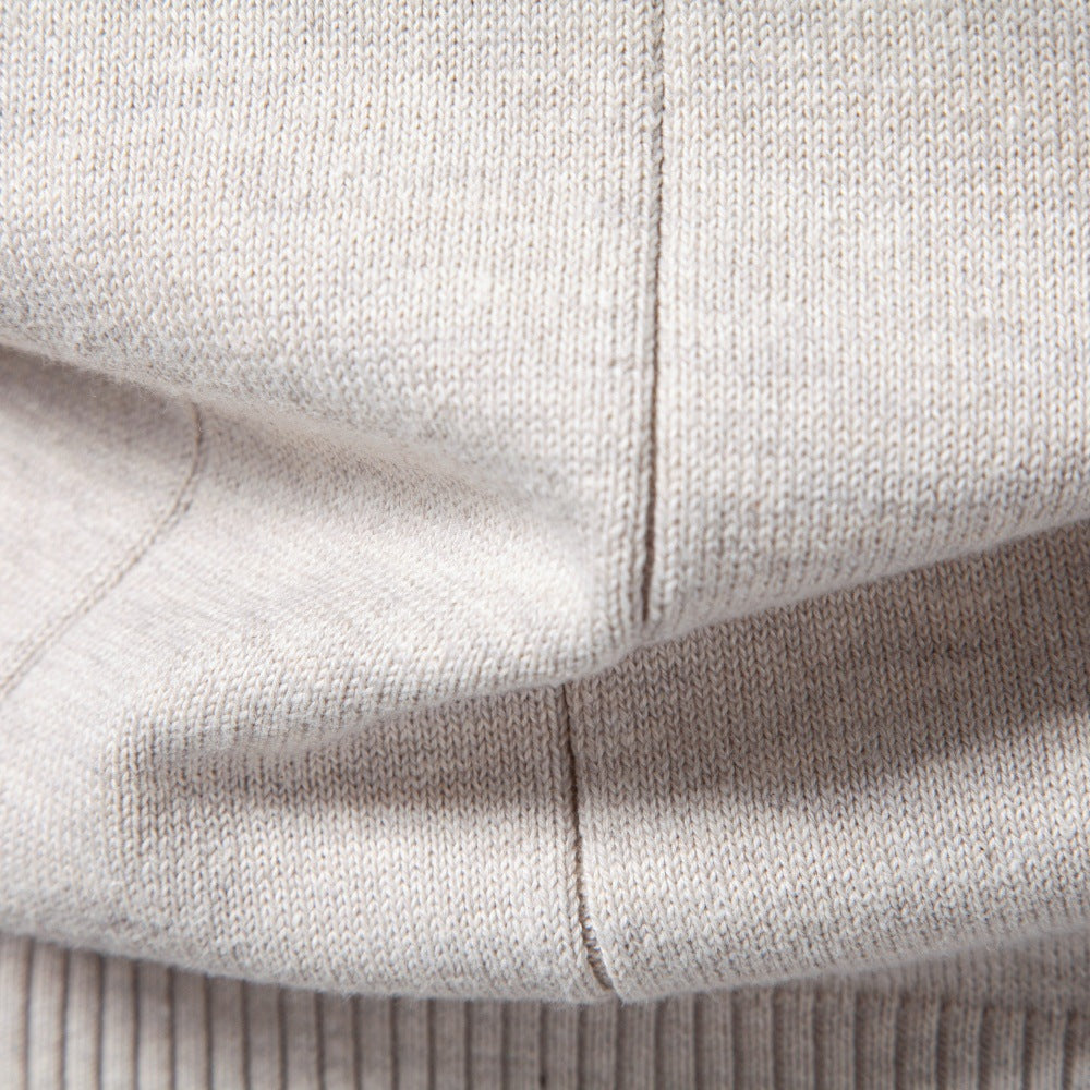 Light gray stretch cotton sweater fabric featuring fine vertical knit lines and a ribbed hem detail.