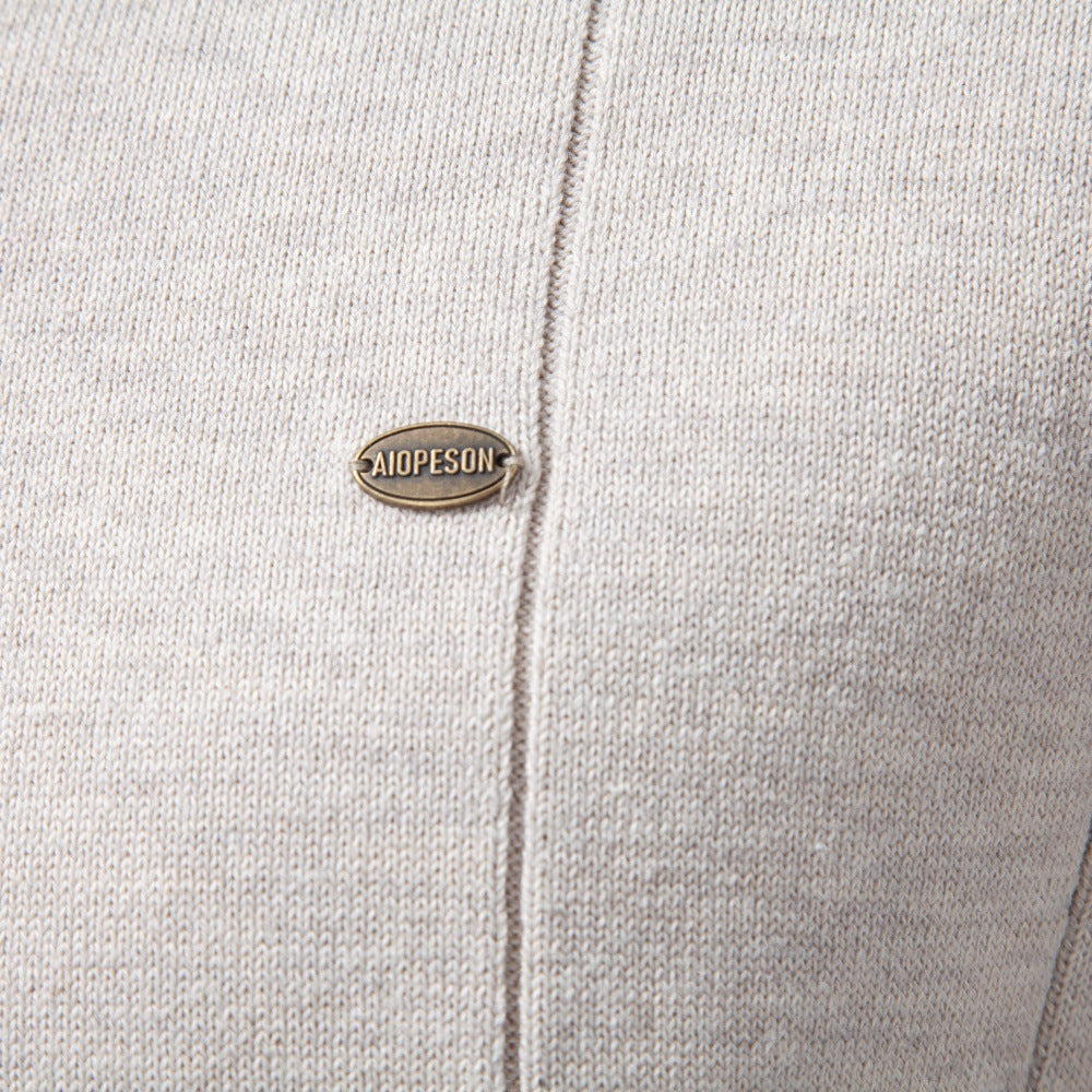 Light gray stretch cotton quarter-zip sweater featuring a fine vertical knit texture and a metallic logo emblem.