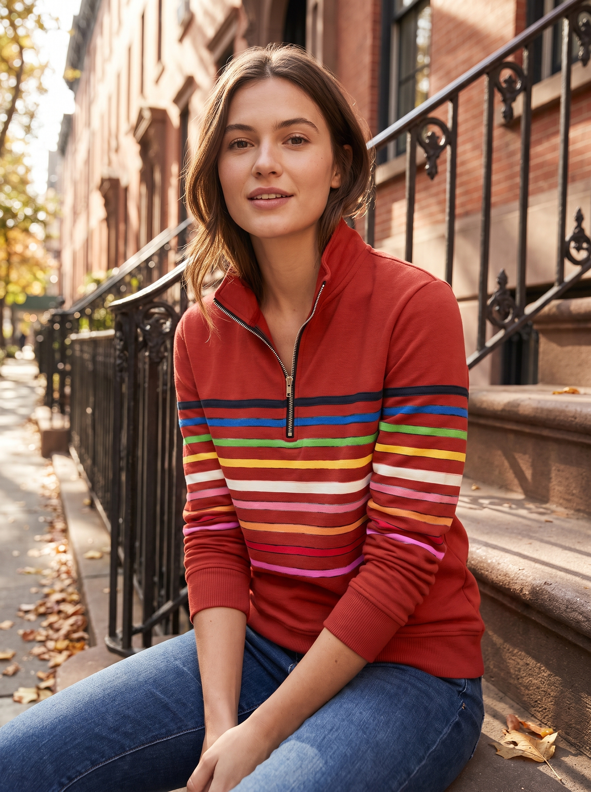Red half-zip sweatshirt in brushed cotton with a stand collar and vibrant horizontal multi-colored stripes.