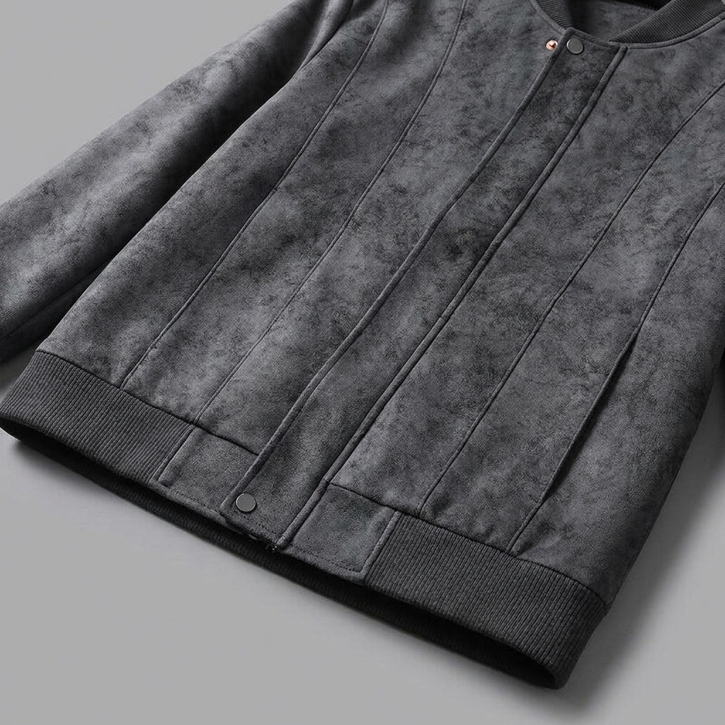 Close-up of a gray suede bomber jacket showing the textured fabric and ribbed sleeve cuff