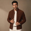 A man wearing a brown suede bomber jacket with a full-zip front and snap band collar, front view