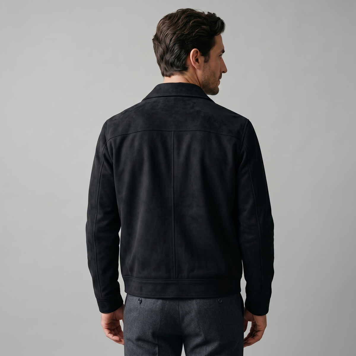 A man wearing a black suede Harrington bomber jacket with ribbed trim, shown from the back