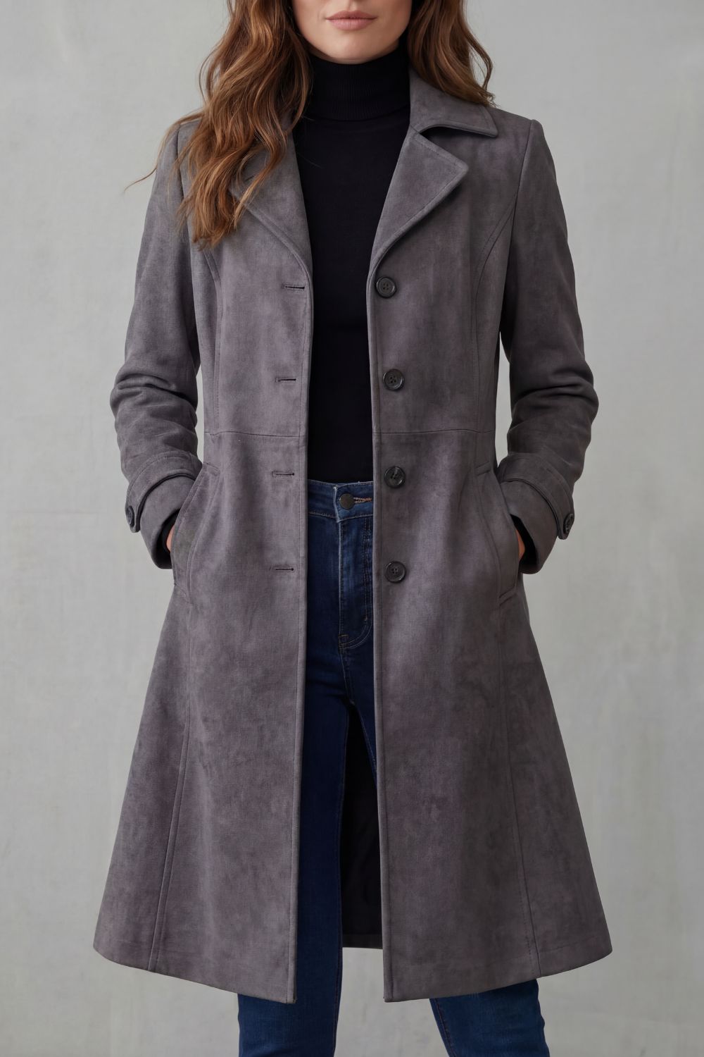A woman wearing a gray suede longline coat with notch lapel and button-front closure