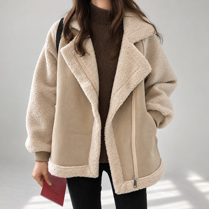 Beige vegan suede aviator jacket with contrast sherpa sleeves, oversized notch lapel, and ribbed knit cuffs.