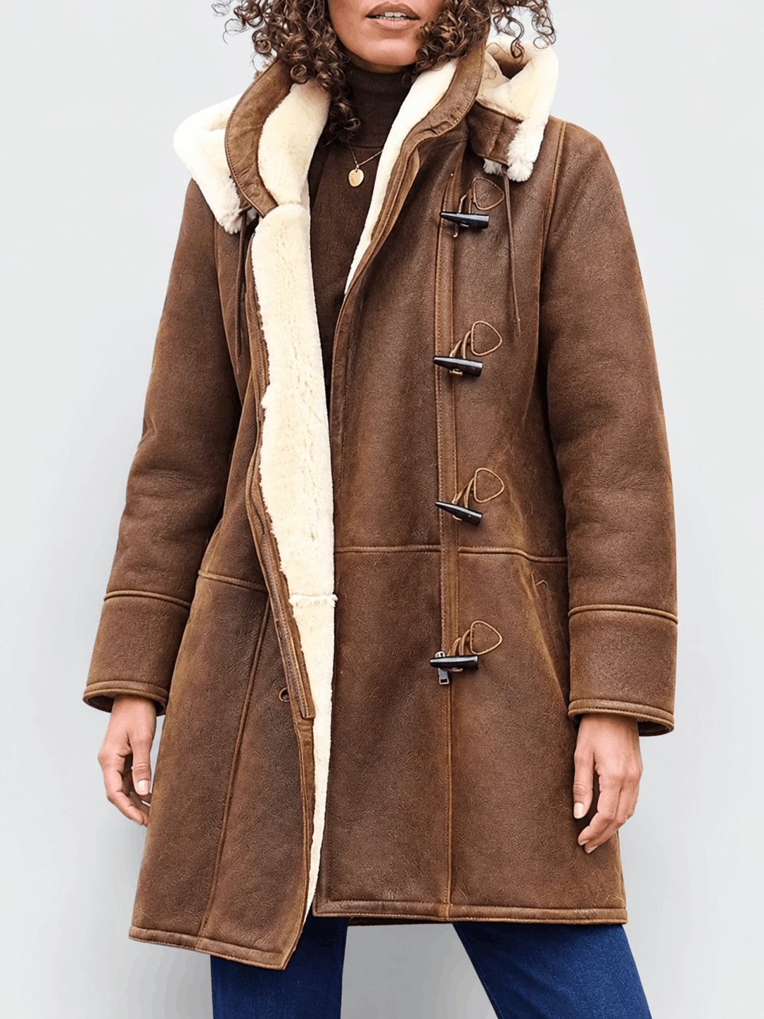 Brown vegan suede duffle coat with cream sherpa lining, toggle fastenings, and a structured, hip-length fit.