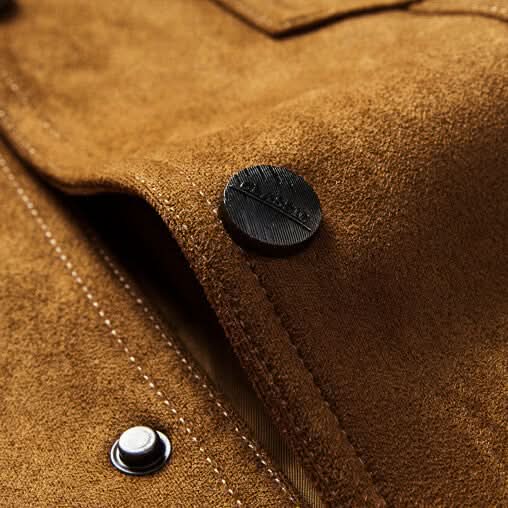 Close-up of a brown suede trucker jacket showing the button-front closure and suede texture
