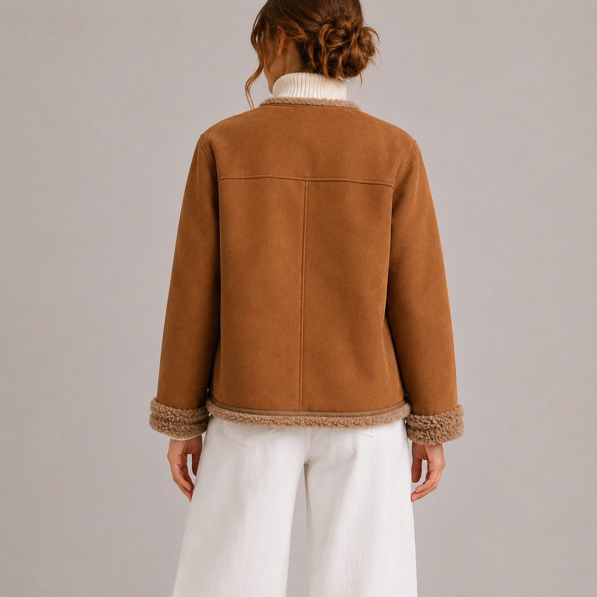 A woman wearing a brown vegan suede jacket with sherpa trim and gold-tone buttons, shown from the back