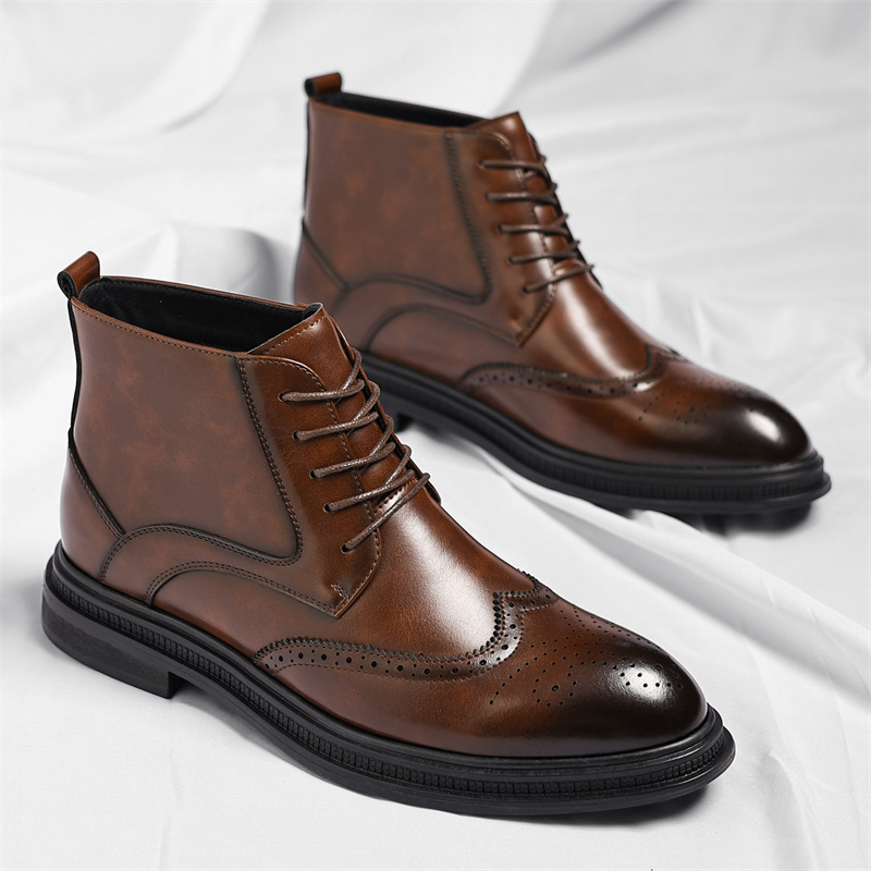 Pair of brown leather brogue lace-up ankle boots with wingtip perforation detailing, standing upright on a white sheet.