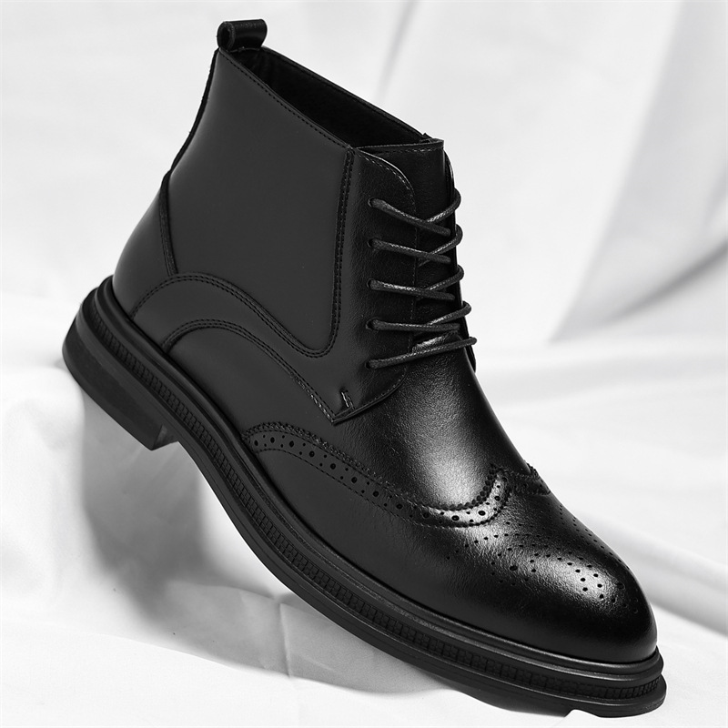 A black leather brogue ankle boot with wingtip perforation detailing, shown at an angle on a white sheet.
