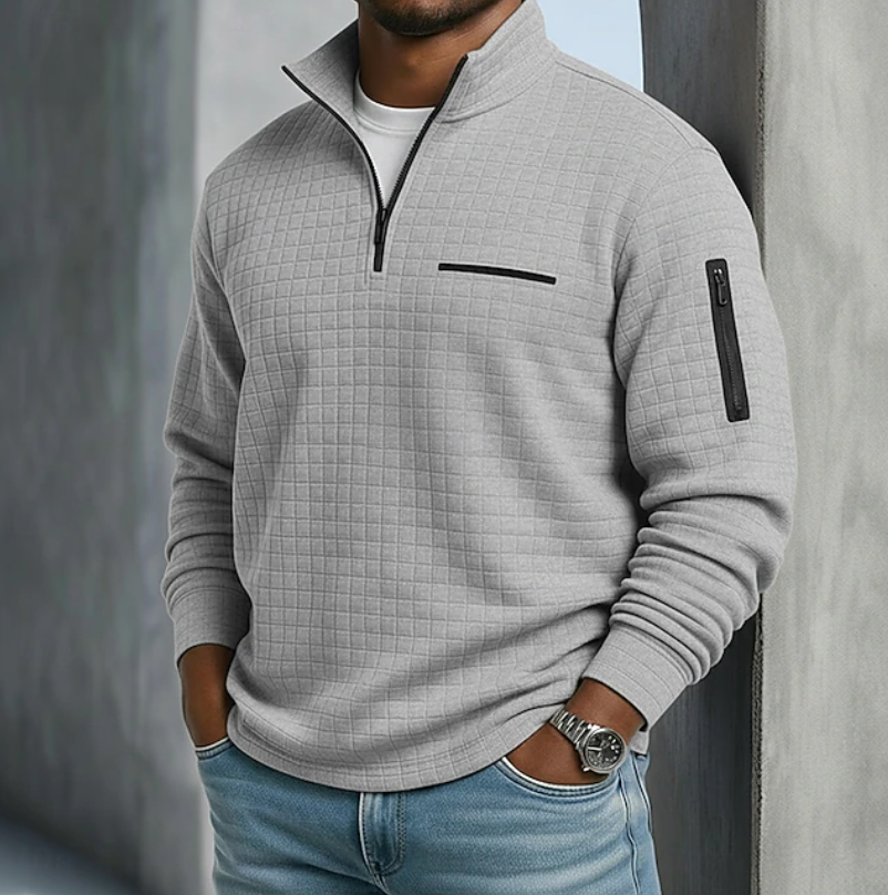 Light gray waffle-knit quarter-zip sweater with a relaxed fit, featuring a chest pocket and zippered sleeve utility pocket.
