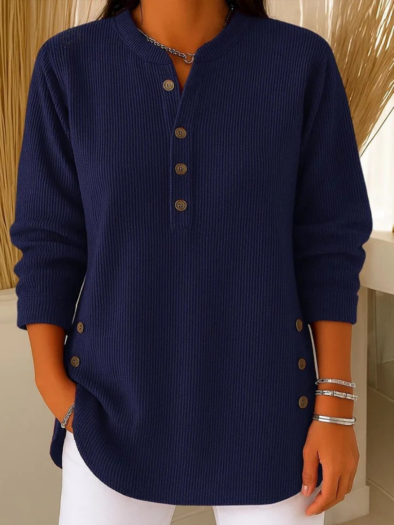 Woman wearing a navy blue waffle knit Henley sweater with a split neckline, decorative buttons, and a relaxed silhouette.