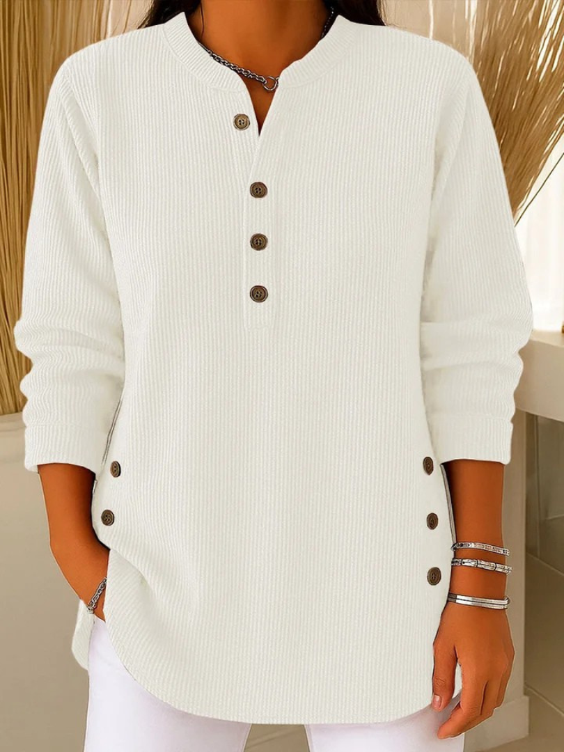 Woman wearing a white waffle knit Henley sweater featuring a split neckline, button placket, side button details, and long sleeves.