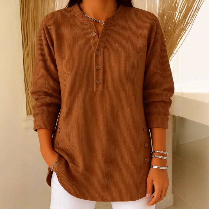 Woman wearing a camel waffle knit Henley sweater with a split neckline, decorative button placket, and long sleeves.