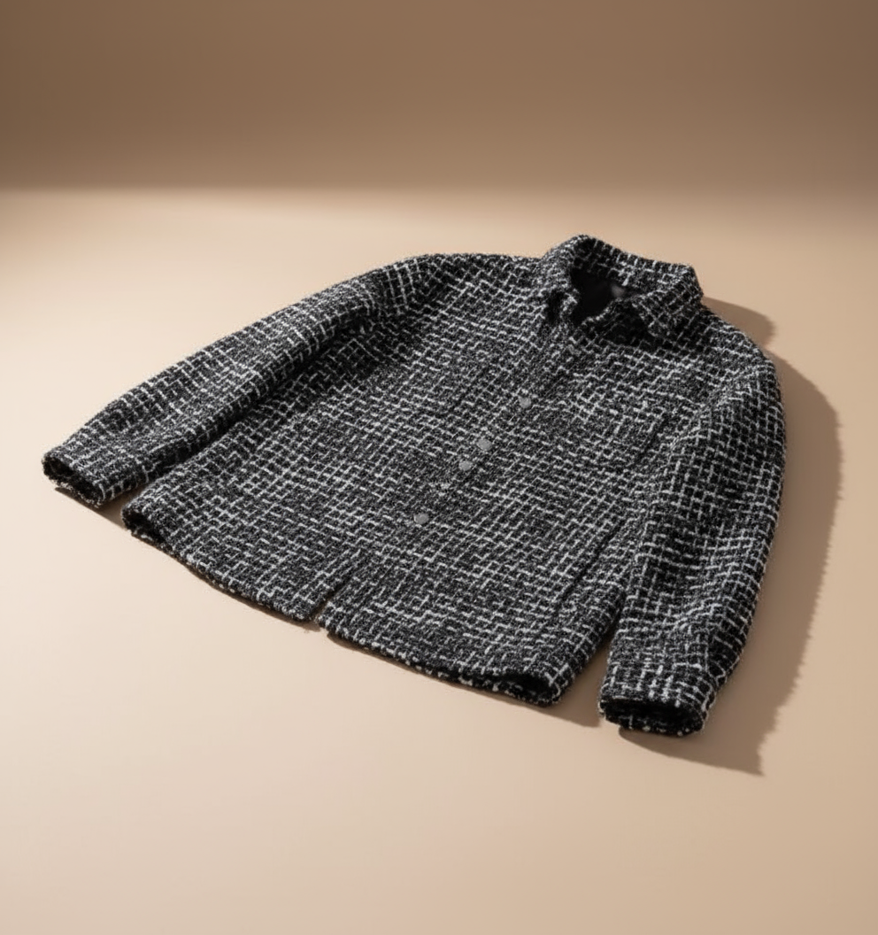 Folded black and white plaid textured overshirt jacket showing its patterned fabric and structured construction.