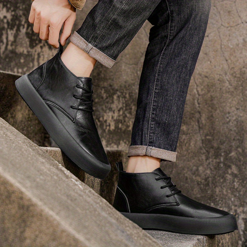 A person adjusts cuffed jeans while stepping down stone stairs wearing black leather chukka-style boots.