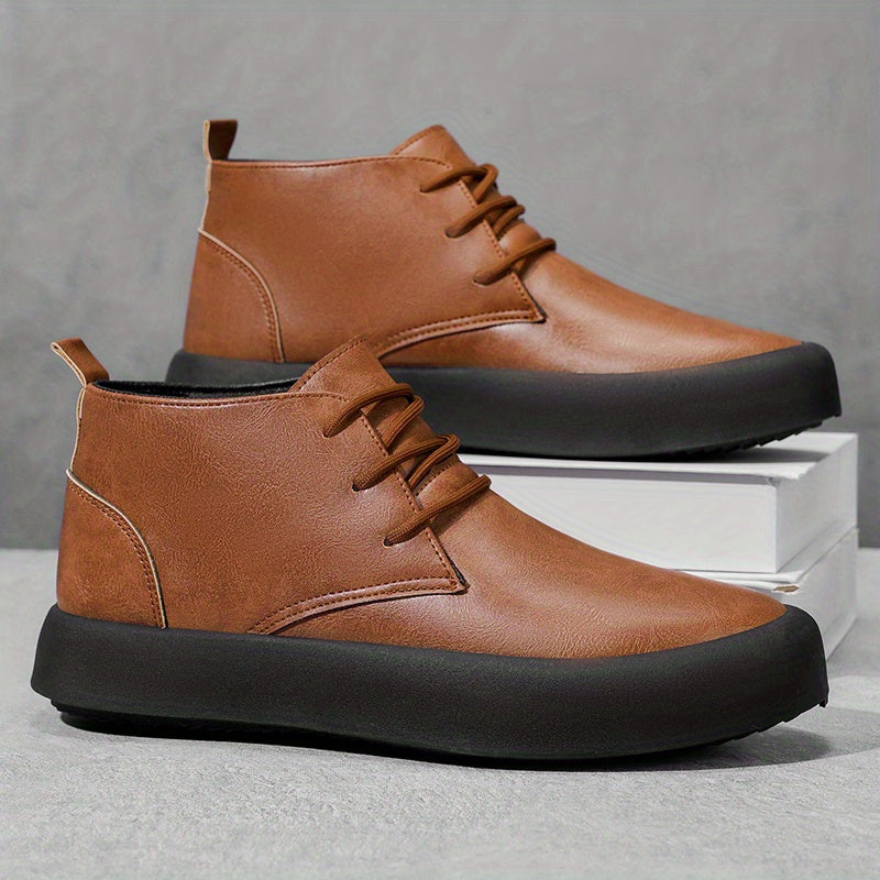 Pair of brown leather chukka-style boots, one shoe propped on a white platform box, against a gray background.