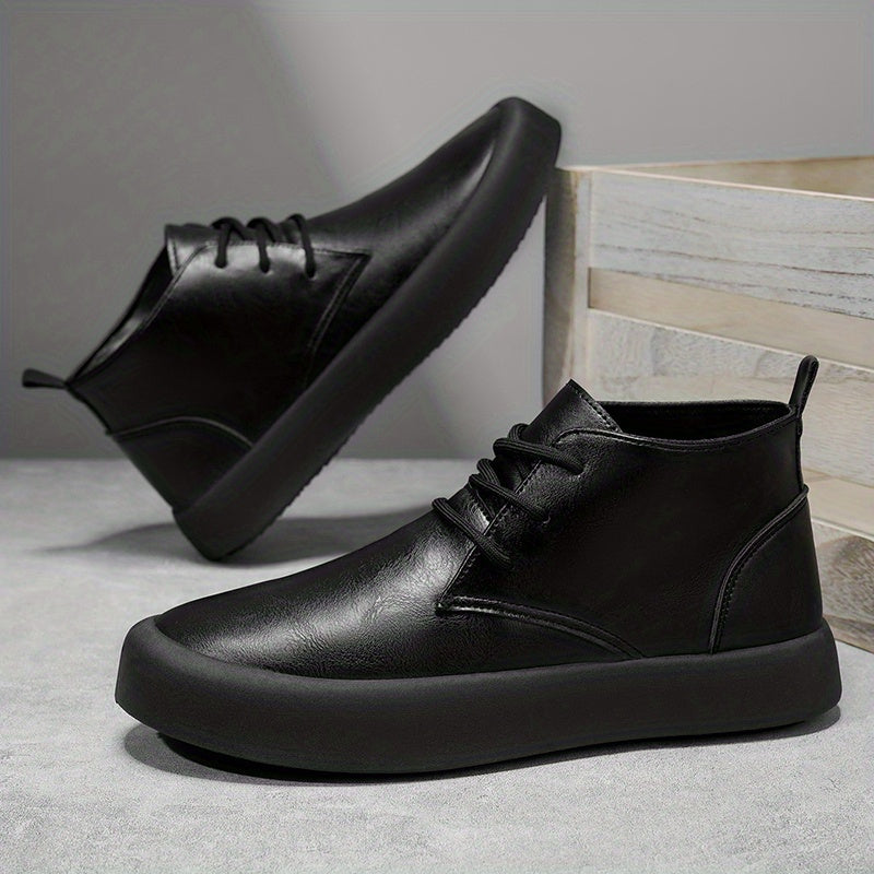 Pair of black leather chukka-style boots in a dynamic angled pose against wooden crate steps.