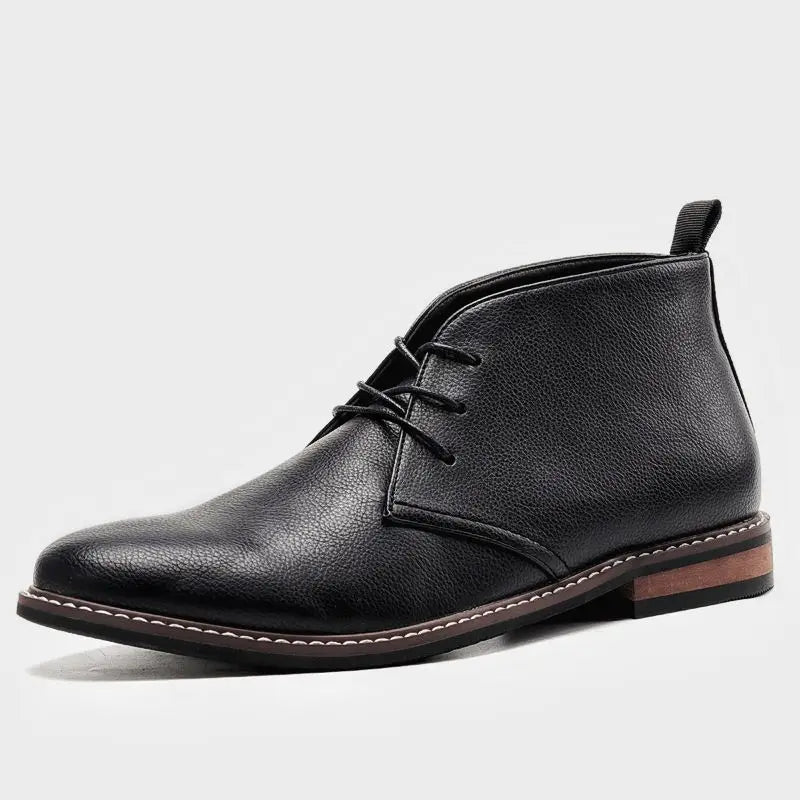 A single black pebbled leather chukka boot with a contrasting brown heel, shown in side profile on a plain white background.