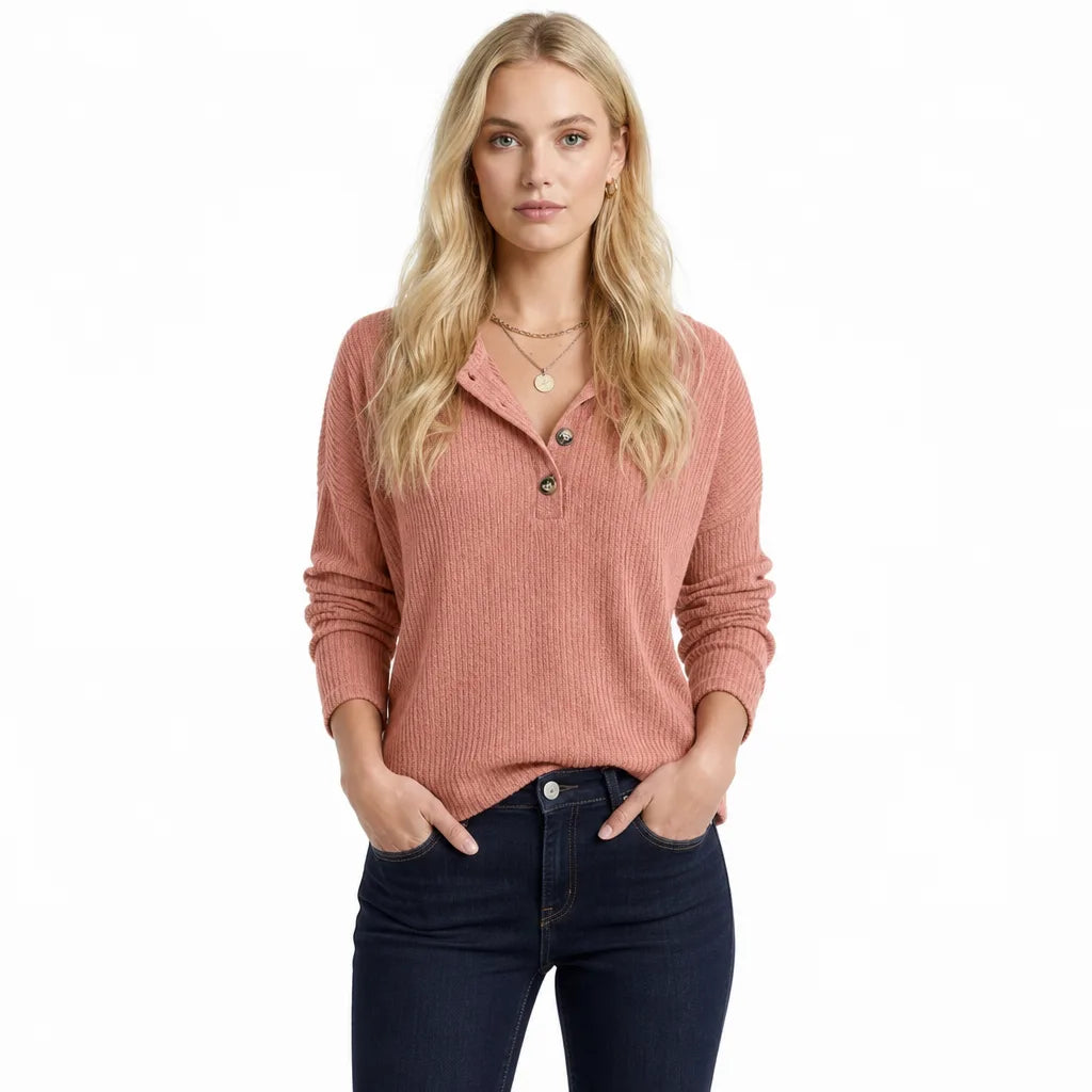 Full-body view of a woman wearing a pink waffle knit Henley sweater with long sleeves and a relaxed fit.