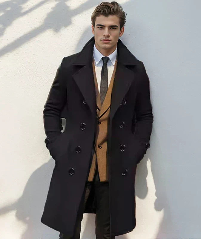 Black double-breasted wool trench coat with structured lapels and a tailored mid-length fit worn over a suit.