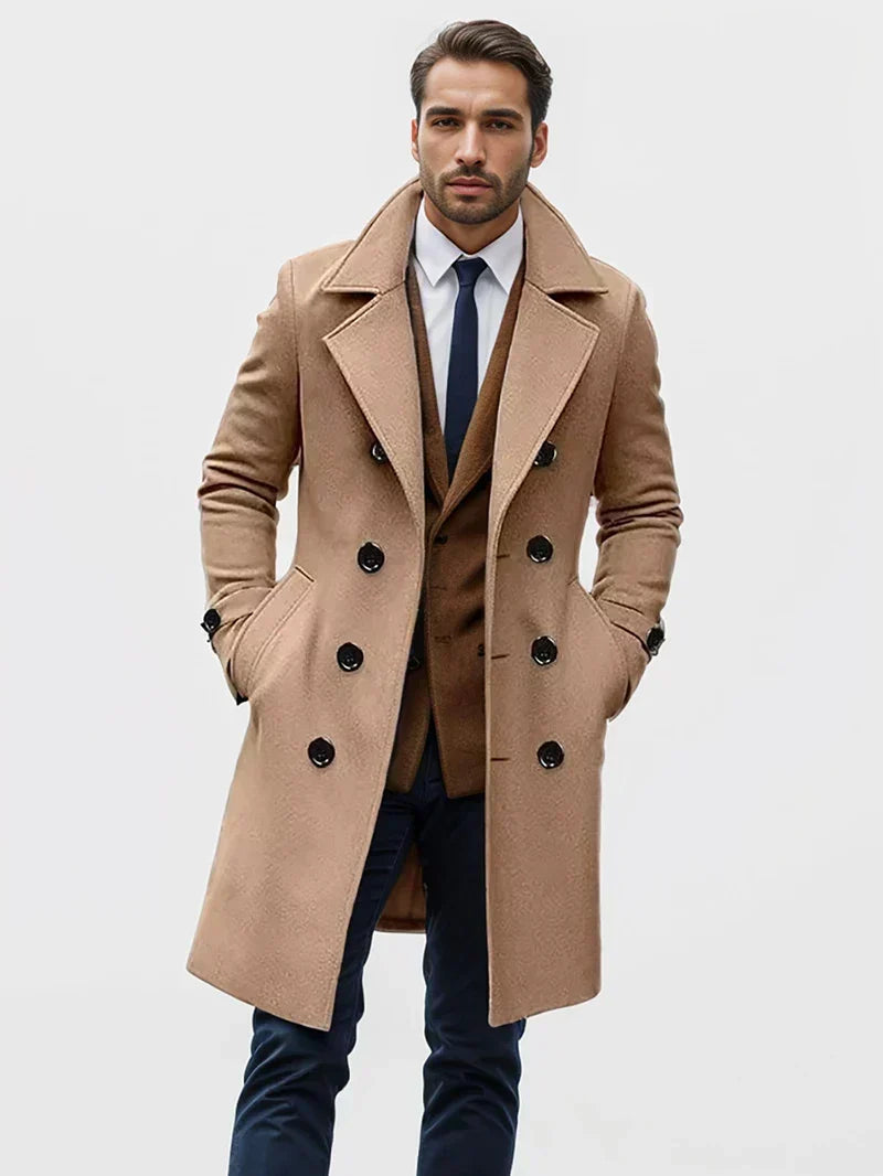 Camel wool double-breasted trench coat with structured lapels and buttoned cuffs worn over a tailored blazer.