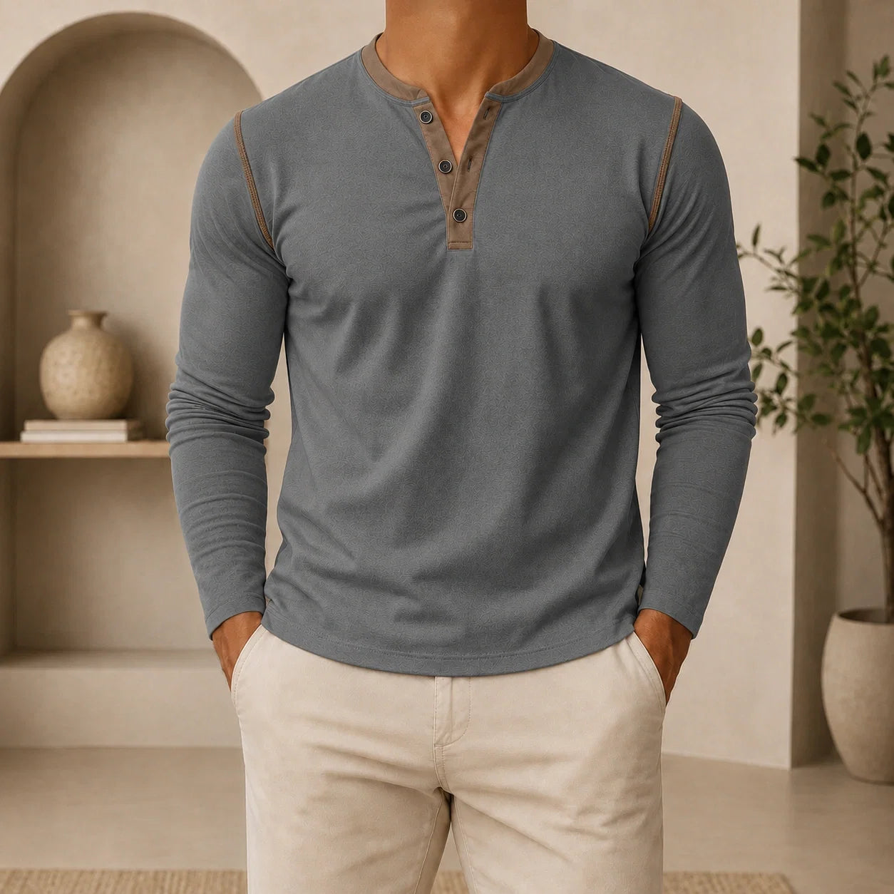Man wearing a gray long-sleeve Henley sweater featuring a contrast navy placket, three-button neckline, and comfortable tailored silhouette.