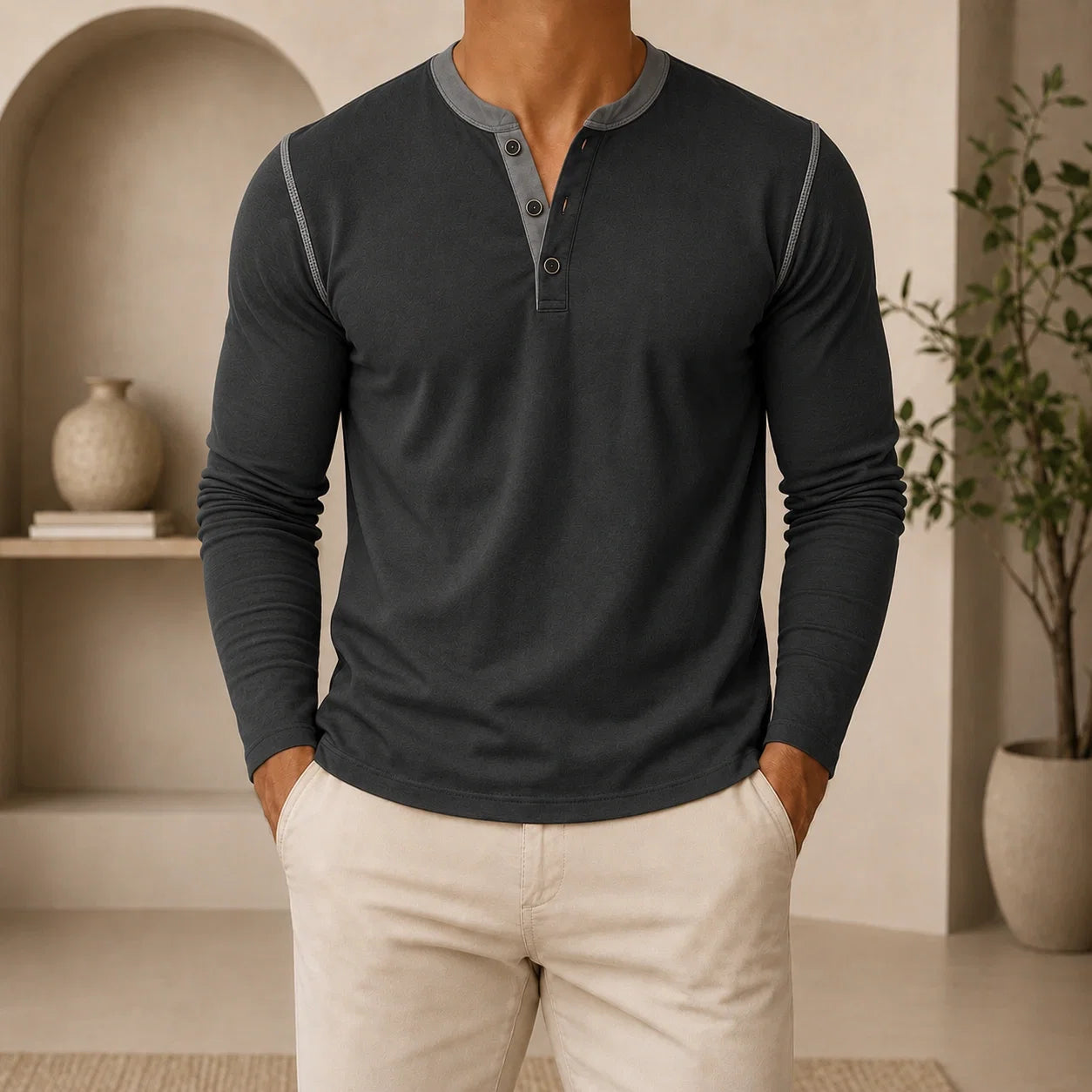 Man wearing a charcoal long-sleeve Henley sweater featuring a contrast brown placket, three-button neckline, and classic slim fit.