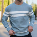 Man wearing light blue striped crewneck knit sweater outdoors, large close-up torso view